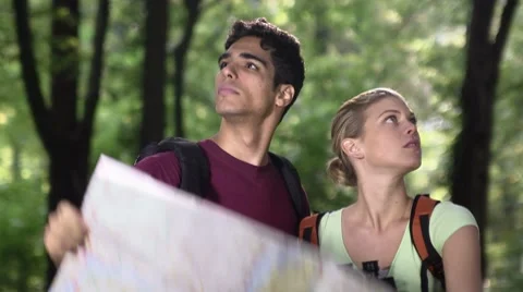 Young couple looking at map during trek after losing orientation Stock Footage 8848027