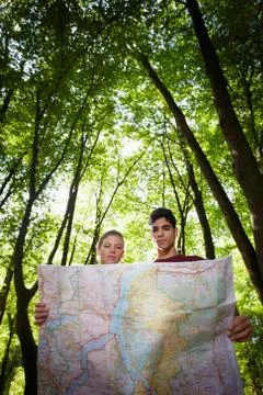 Young couple looking at map during trek Stock Photos