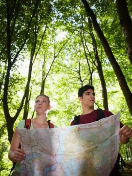 Young couple looking at map during trek Stock Photos