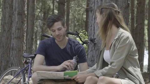 Young couple looking at map in woods Stock Footage 75199256