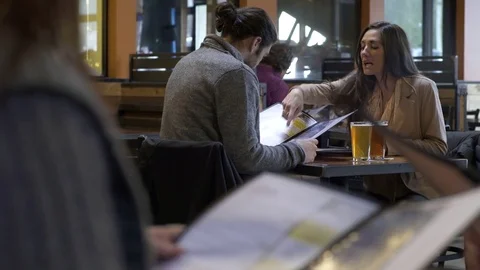 Young couple looking at a menu in a bar 動画素材 77079047