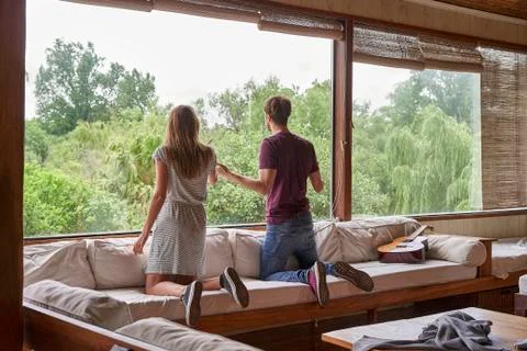Young couple looking out through window 스톡 사진