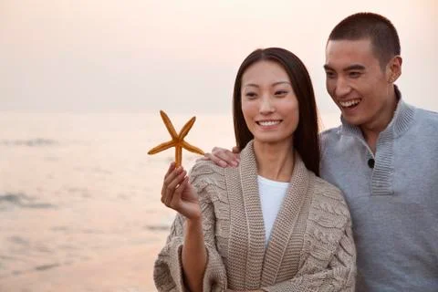 Young Couple Looking At a Seashell Stock Photos