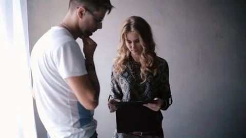 Young couple looking a tablet PC and are discussing something Stock Footage 70312055