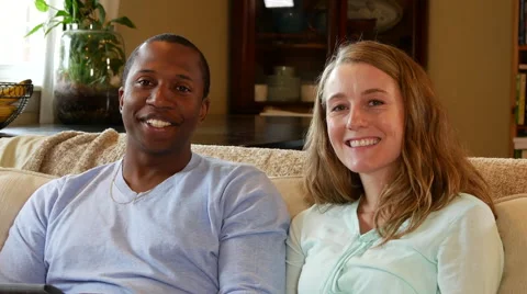 Young couple looking at tablet talk and laugh, smiles at camera Stock Footage 53018290