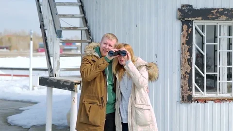 Young couple looking through binoculars in the background of the lighthouse Stock-Footage 74911538