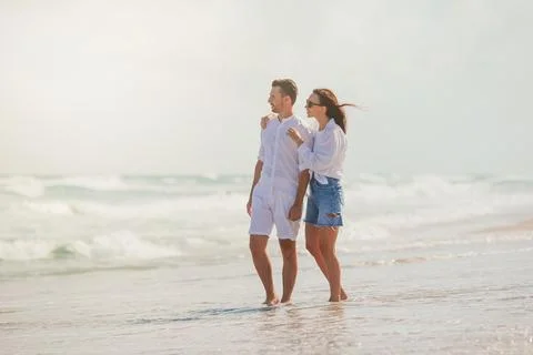 Young couple in love on the beach summer vacation. Happy man and woman look at Stock Photos