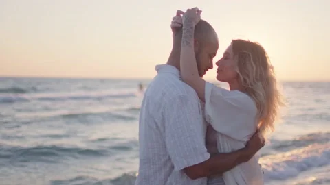 Young couple in love looking at each other at the beach Stock Footage 159536906