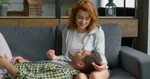 Young couple in love is lying on sofa at home, enjoying their relationships Stock Footage 114888491