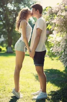 Young couple in love, sensual kiss in sunny summer day Stock Photos