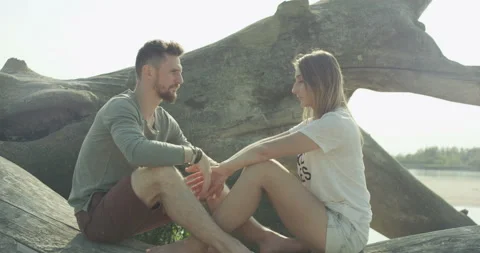Young couple in love sitting on the tree Stock Footage 99426025