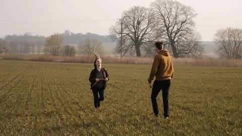 Young couple in love together launch a boomerang in a field Stock Footage 129009986