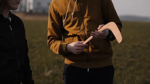 Young couple in love together launch a boomerang in a field Stock Footage 129010546