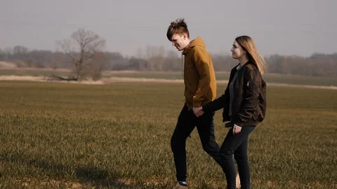Young couple in love together launch a boomerang in a field Stock Footage 129010641