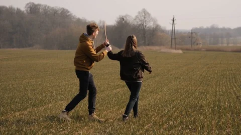 Young couple in love together launch a boomerang in a field Stock Footage 129010779