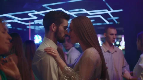 Young couple of lovers dancing together in neon light of night club. Romantic da Stock Footage 199486369