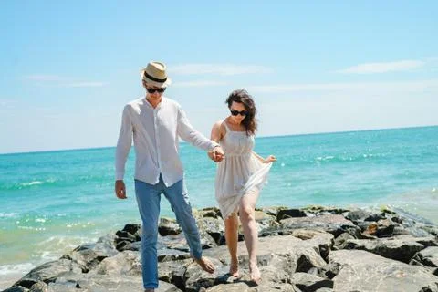 A young couple of lovers, a guy and a girl on the ocean, in white clothes on the Stock Photos