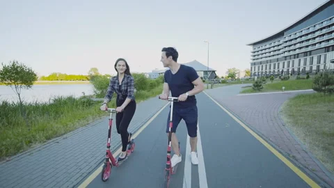 Young couple of lovers ride a scooter in city street on the first date Stock Footage