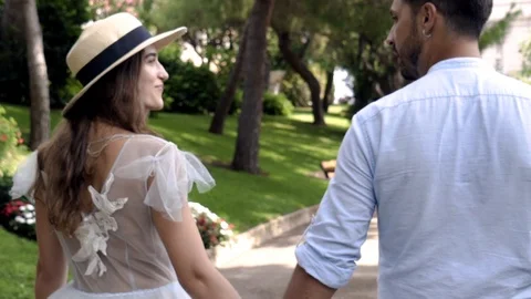 Young couple of lovers walking by handle in park. Action. Lovely couple talking Vidéo 115039338