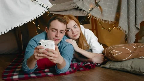 A young couple is lying and taking pictures of themselves with a polaroid Stock Footage 219636753
