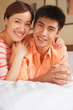 Young Couple Lying on Bed Stock Photos