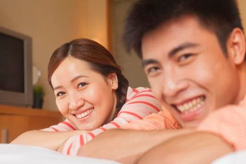 Young Couple Lying on Bed Stock Photos