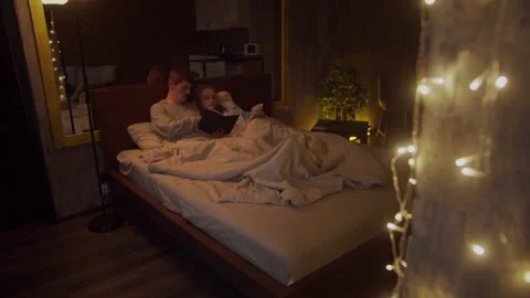 Young couple lying in bed reading books. Spending time together without the Stock Footage 145083549
