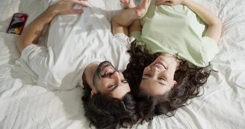Young couple lying on bed, they are happy together, top view Video stock 235078139