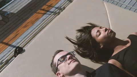 Young couple lying on deck of moving ship on summer day. Stock Footage 76518278