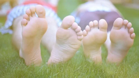 Young couple lying on green grass outdoors in spring park. Stock Footage 77951889