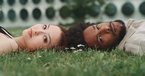 A young couple lying on the ground and looking at the camera Stock Footage 201116700