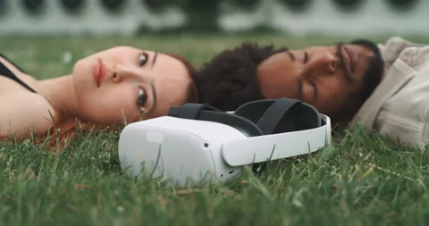 A young couple lying on the ground with virtual reality goggles Stock Footage 201115164