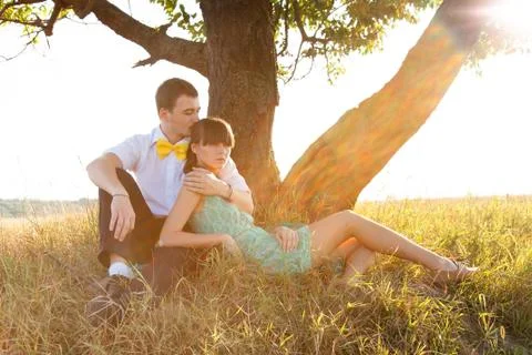 Young couple lying under the tree Stock Photos