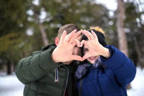Young couple make heart shape by fingers. Stock Photos