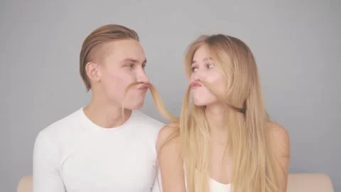 A young couple make a mustache from strands of hair. Stock Footage 142564604