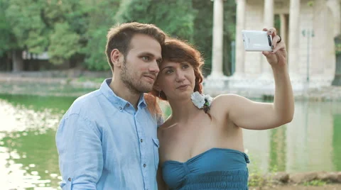 Young couple makes romantic selfie near small lake in a public park Video stock 41752191