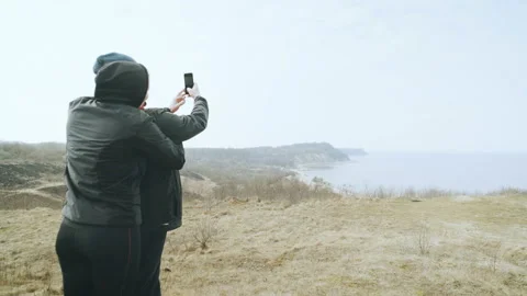 A young couple makes selfie on the background of a beautiful sea bay. Stock Footage 87919125