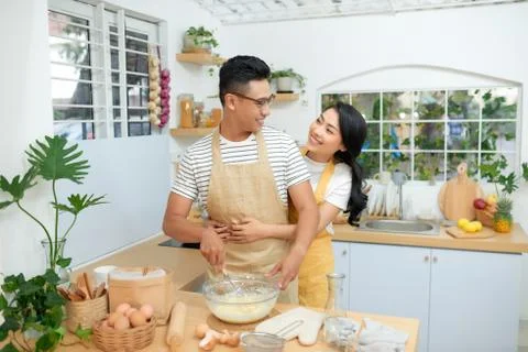 Young couple making dough in kitchen together Stock Photos