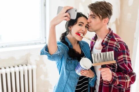 Young couple making a selfie while working to the renovation of 스톡 사진