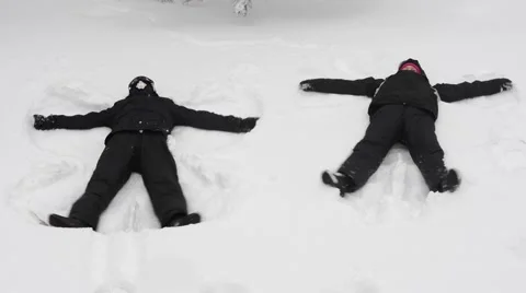 Young couple making snow angels Stock Footage 47454672
