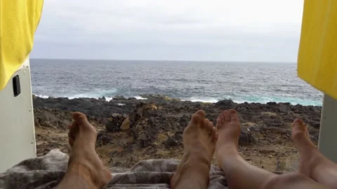 Young couple in a MiniVan lying down relaxing Stock Footage 166187176