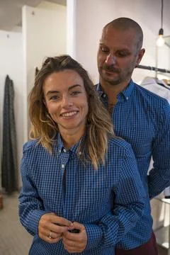 Young couple of models posing in a funny way trying on some clothes in a fa.. Stock Photos