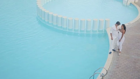 Young couple near luxury modern white pool Stock Footage