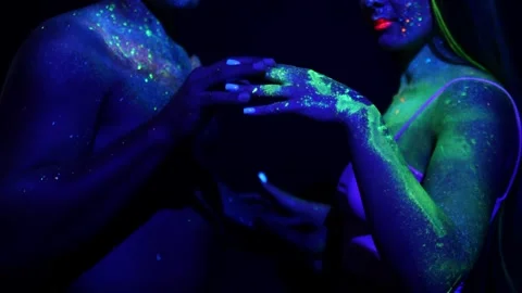 Young couple in neon light touch each others hands. Stock Footage 314298597