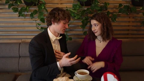 Young couple on offline date as man shows phone and talks about online  Stock Footage 328284332