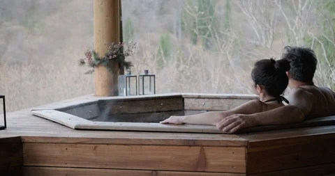 The young couple in an open-air bath with a view of the mountains. Stock Footage 119535862