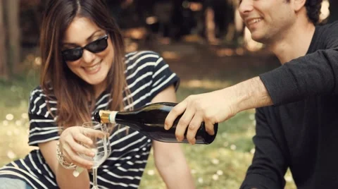 Young couple open a bottle of white wine in the garden Stock Footage 62978572