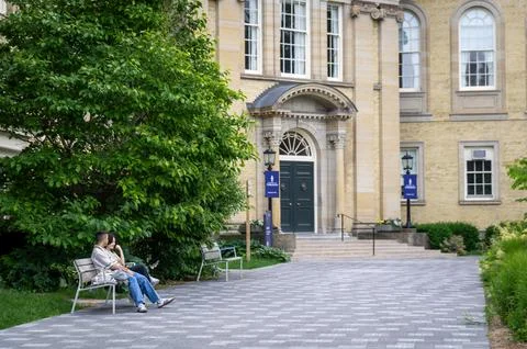 A young couple or students talking on a bench at the University of Toronto Stock Photos