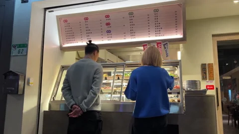 Young Couple Ordering Authentic Asian Street Food at a Local Eatery at Night Video stock 335263669