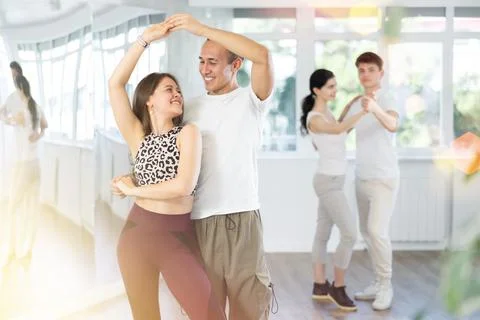 Young couple performs an expressive salsa in bright, modern dance studio during Stock Photos